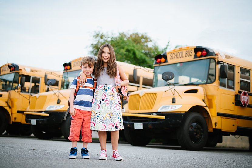 Kids pose for portrait in front of a Nashua NH school bus