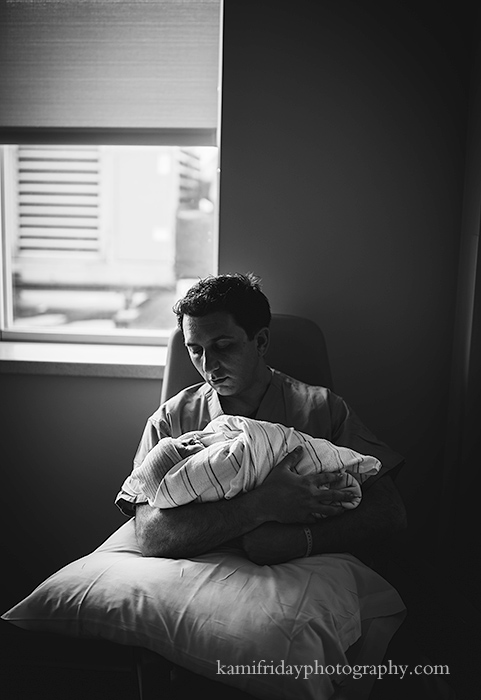 Nashua NH newborn birth photographer photographs father holding baby for the first time at St Joseph hospital