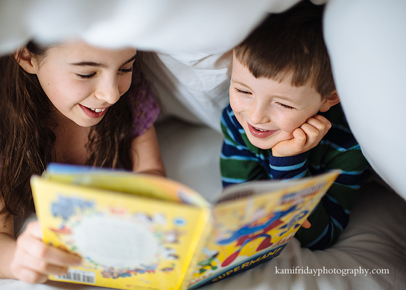 Greater Boston family photographer caputures siblings reading together under a blanket