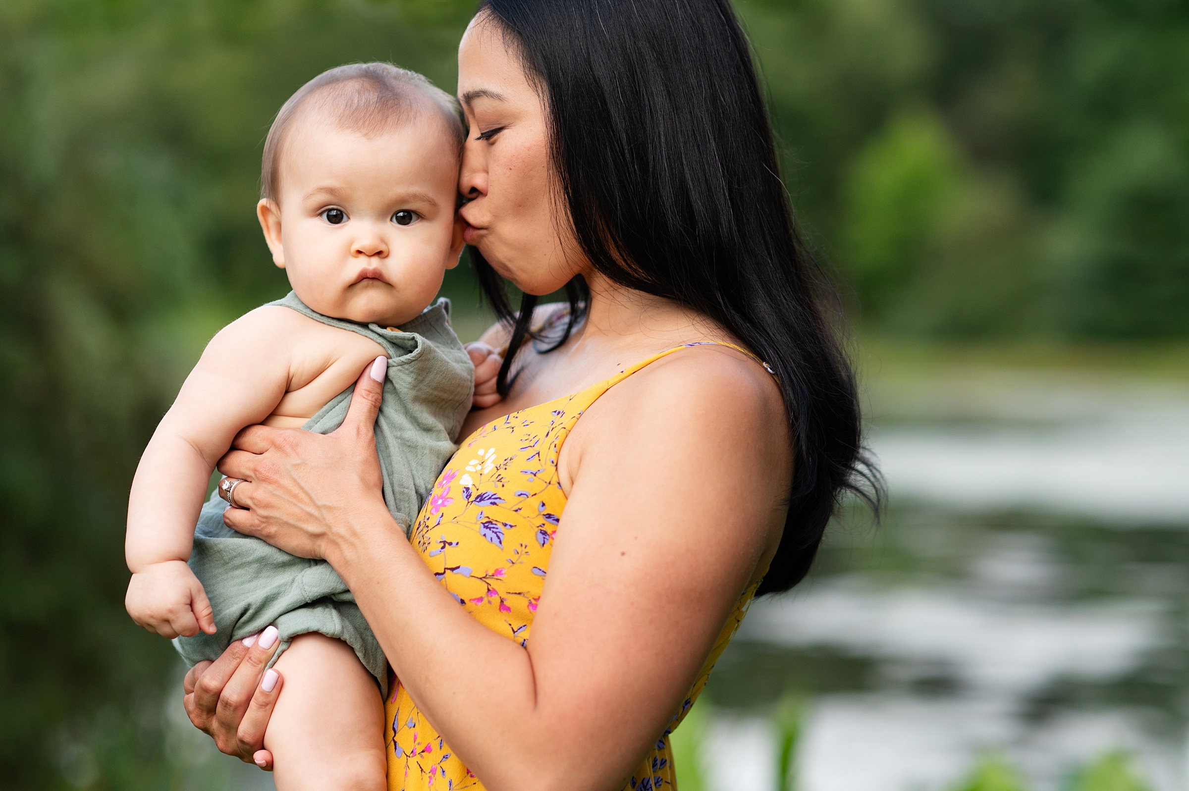 Mother kisses baby during family photo session at Benson Park in Hudson NH.