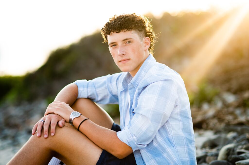 Sun rays shine on Bishop Guertin senior as he poses for his senior pictures at Parson's beach in Kennebunk Maine.