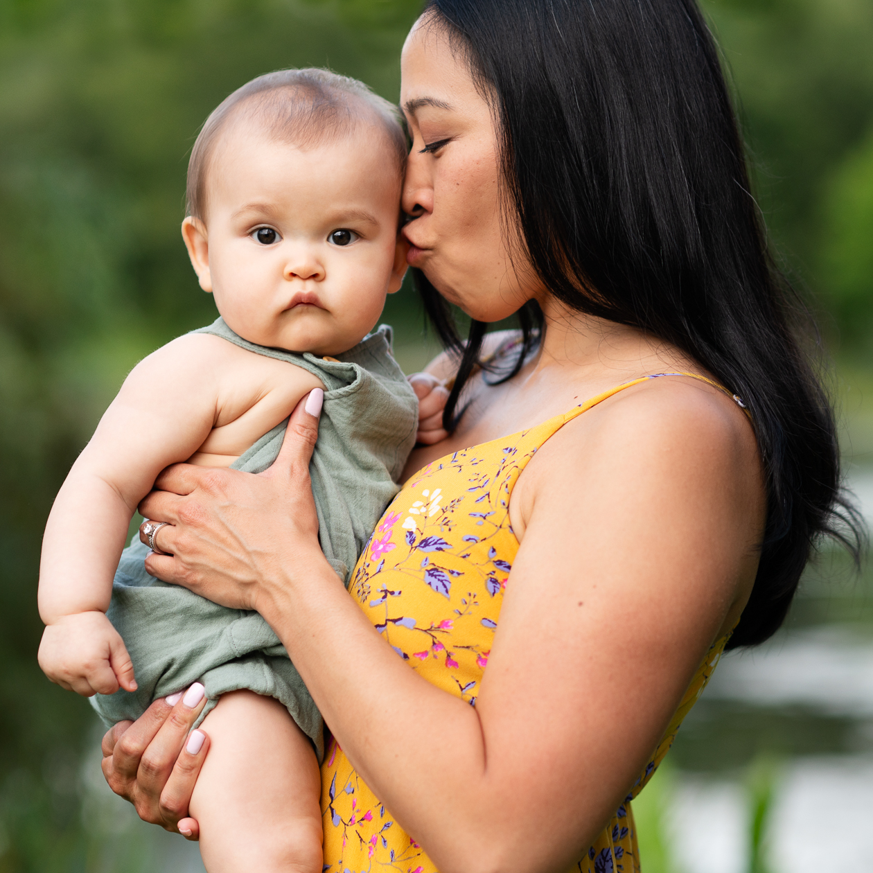 Mother kisses baby during family photo session at Benson Park in Hudson NH.