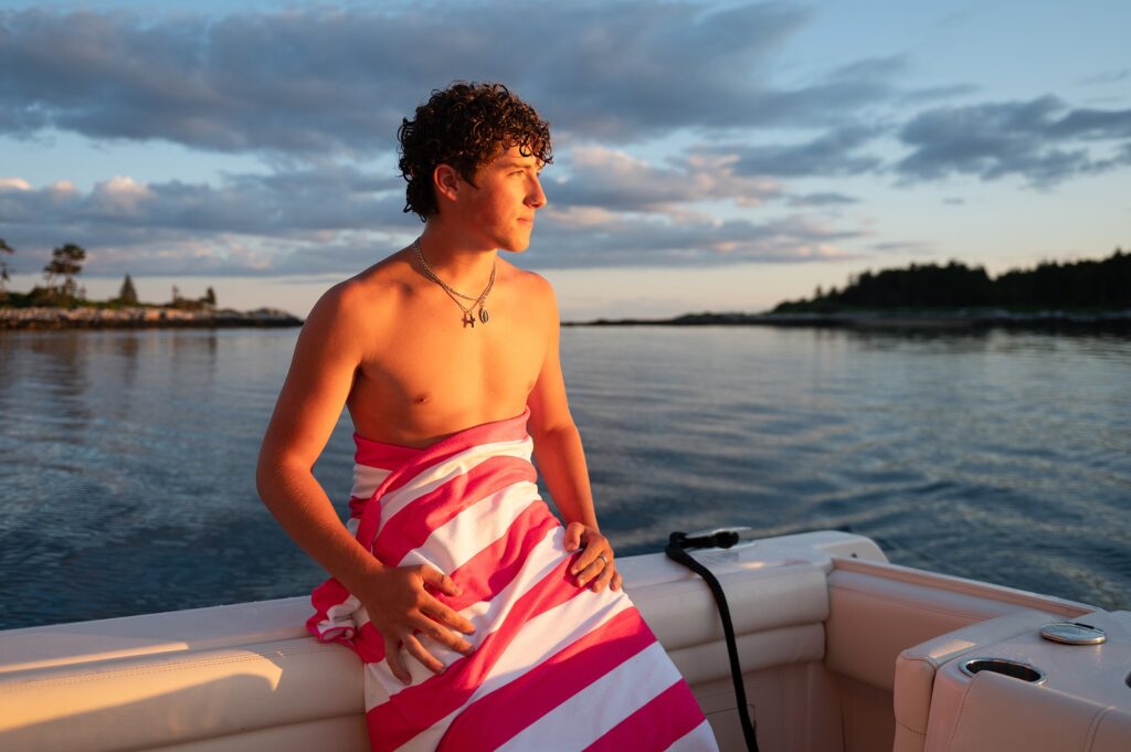 Teen boy out on the ocean in Maine with sun streaming on his face.