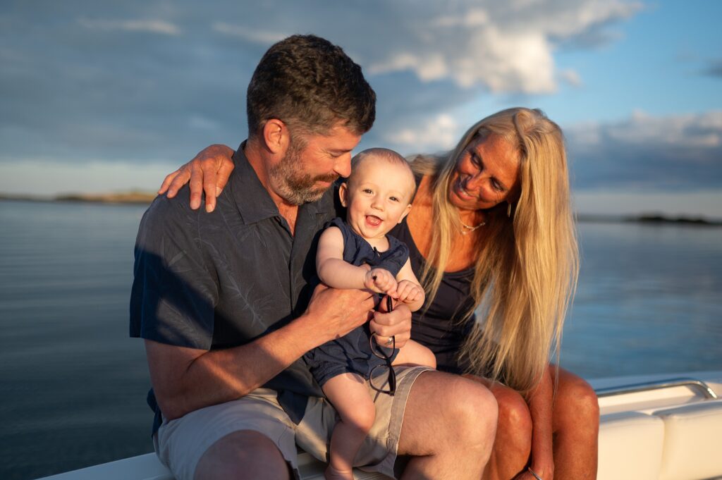 Grandparents casually pose with their grandson on their boat in Southern Maine.